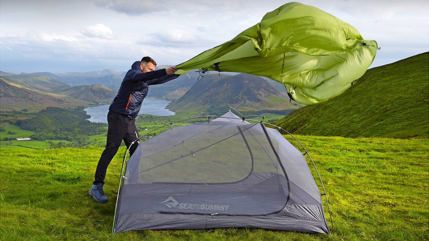 Tester James Forrest pitching Sea To Summit tent on a hilltop