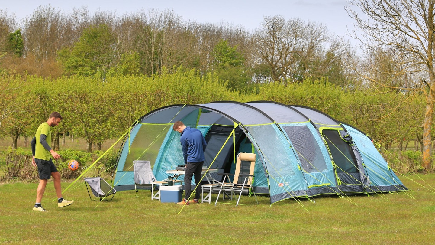 Campers standing outside Coleman Meadowood 6L BlackOut Tent