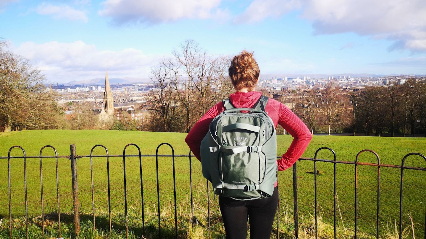 Fliss Freeborn wears the Osprey Sojourn Porter 30L overlooking a park