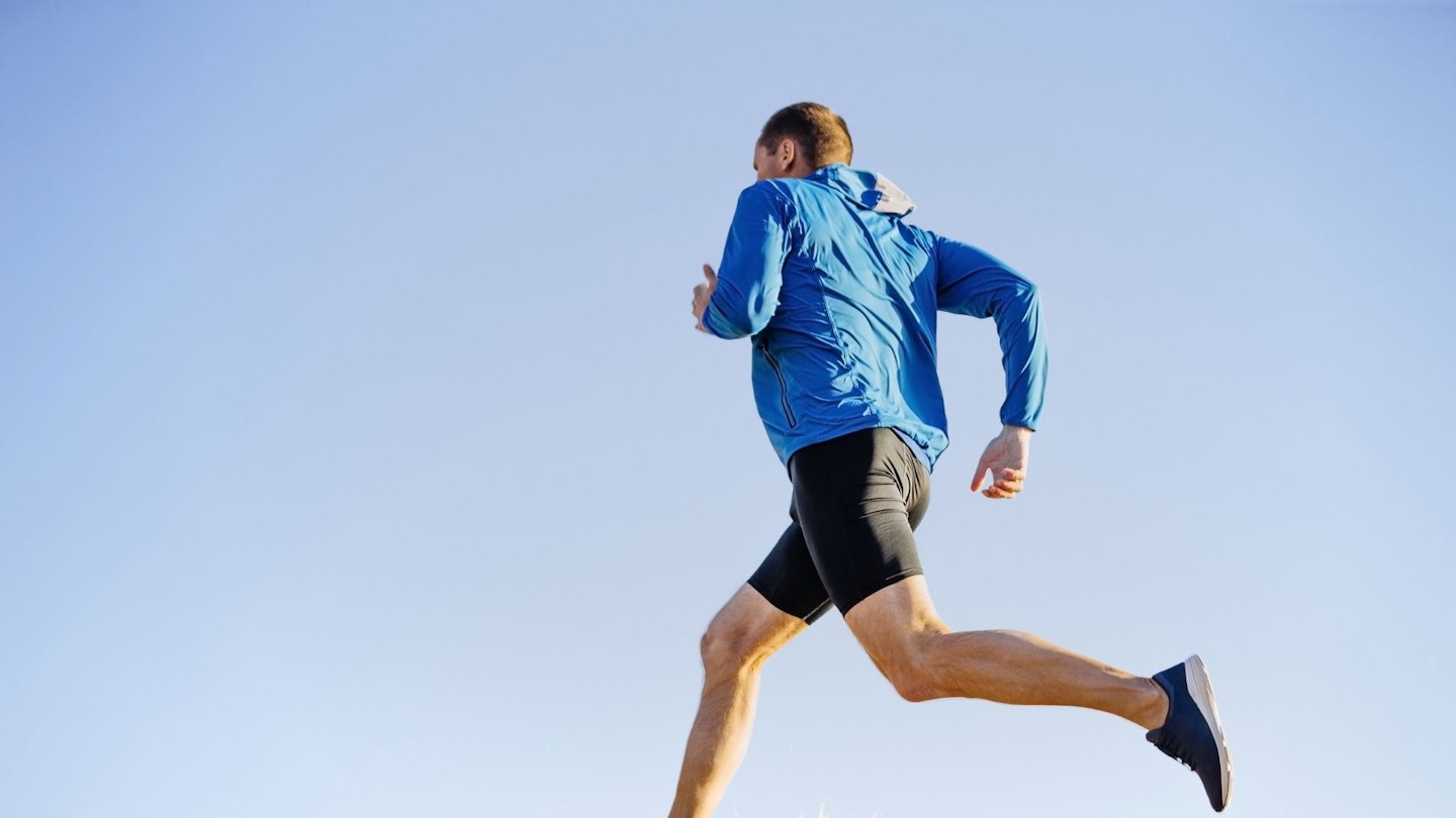 Trail runner wearinThe Best Windproof Trail Running Jacketsg a blue jacket