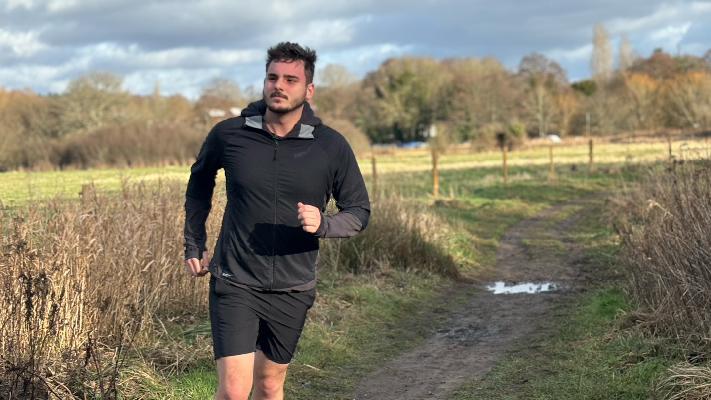 trail runner wearing the inov8 performance hybrid jacket